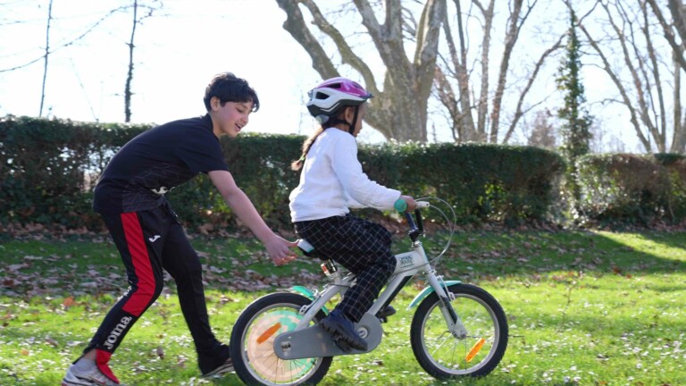 Atelier vélo proposé par le CSC Le Boat - Fillette qui apprend à faire du vélo
